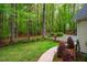 Landscaped backyard with a stone pathway and verdant trees at 18 Green Ridge Ln, Pittsboro, NC 27312