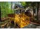 Multi-level deck and outdoor spaces with stairs down to a stone patio for outdoor entertaining in a wooded setting at 18 Green Ridge Ln, Pittsboro, NC 27312