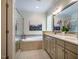 Bright bathroom with a soaking tub, double vanity, large mirror, and a separate glass enclosed shower at 18 Green Ridge Ln, Pittsboro, NC 27312
