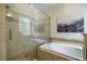 Featuring tile and glass enclosed shower next to a tub with decorative tile and framed art on the wall at 18 Green Ridge Ln, Pittsboro, NC 27312