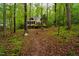 Secluded home exterior with deck nestled amongst trees, providing a private and serene setting at 18 Green Ridge Ln, Pittsboro, NC 27312