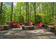 Cozy stone fire pit surrounded by chairs, perfect for outdoor gatherings in a tranquil wooded setting at 18 Green Ridge Ln, Pittsboro, NC 27312