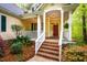 Inviting front porch with brick steps, white columns, and lush landscaping at 18 Green Ridge Ln, Pittsboro, NC 27312