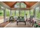 Bright sunroom with large windows offering peaceful views of nature, complete with cozy seating and natural light at 18 Green Ridge Ln, Pittsboro, NC 27312