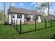 Well-maintained backyard with black metal fence, green grass, and wooden deck at 20 Izuba Day Dr, Timberlake, NC 27583