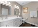 Bathroom featuring double vanity sinks, framed mirrors, white cabinets, and hardwood floors at 20 Izuba Day Dr, Timberlake, NC 27583