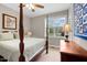 Bedroom with four-poster bed and dresser near a window with a green view at 20 Izuba Day Dr, Timberlake, NC 27583