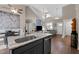 Open concept living and dining area with kitchen island with sink and black cabinets at 20 Izuba Day Dr, Timberlake, NC 27583