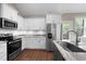 Kitchen showcasing stainless steel appliances, granite countertops, white cabinetry, and hardwood floors at 20 Izuba Day Dr, Timberlake, NC 27583