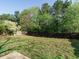 Fenced backyard with green grass and mature trees in the background create a private, peaceful outdoor space at 202 Providence Hall Dr, Sanford, NC 27330