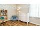 Bedroom with a charming star-themed mural, wood floors, a white dresser, and a cozy blue chair at 202 Providence Hall Dr, Sanford, NC 27330
