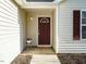 Close-up of front porch area showcasing entrance with a decorative flower pot, light fixture, and storm door at 202 Providence Hall Dr, Sanford, NC 27330