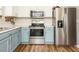 Updated kitchen featuring white and blue cabinets, stainless steel appliances, and ample counter space at 202 Providence Hall Dr, Sanford, NC 27330