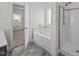 Bright bathroom features a soaking tub, separate shower, and gray tile flooring at 205 Mcclellan Trl, Mebane, NC 27302