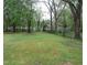 Expansive back yard surrounded by mature trees provides a private outdoor space at 2117 Wrenn St, Burlington, NC 27215