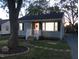 Inviting home with a well-lit porch, manicured lawn, and charming curb appeal as dusk settles in at 2117 Wrenn St, Burlington, NC 27215