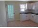 Well-lit kitchen featuring white cabinets, black countertops, tile backsplash, and a tile floor at 2117 Wrenn St, Burlington, NC 27215