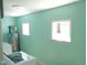 This mint-colored laundry room features modern machines, natural light, and efficient water heating at 2117 Wrenn St, Burlington, NC 27215