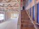 Spacious unfinished staircase with exposed framing leading to an open living area with bright, natural light at 215 Pond View Ct # 6, Fuquay Varina, NC 27526