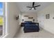 Well-lit bedroom with a ceiling fan, windows, and shelving displays decor at 224 Clear River Pl, Cary, NC 27519