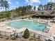 Aerial view of a large community pool surrounded by lounge chairs and lush greenery, perfect for summer relaxation at 224 Clear River Pl, Cary, NC 27519