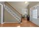 Inviting foyer with hardwood floors, staircase, and view into home office at 224 Clear River Pl, Cary, NC 27519