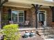 Charming front porch is accented by stone, wrought iron railing, and potted plants at 224 Clear River Pl, Cary, NC 27519
