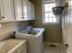 Bright laundry room features a modern washer, dryer, and ample storage cabinets for convenience at 224 Clear River Pl, Cary, NC 27519
