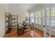 Sunlit home office featuring built-in shelving and hardwood floors at 224 Clear River Pl, Cary, NC 27519