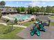Community pool with an adjacent clubhouse and playground in a lush landscaped setting at 224 Clear River Pl, Cary, NC 27519