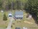 Charming home with a detached garage, well-maintained lawn, and long driveway, surrounded by trees at 230 Bradley Dr, Benson, NC 27504