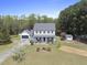 Expansive view of a charming home with lush greenery, a detached garage, and well-manicured landscaping at 230 Bradley Dr, Benson, NC 27504