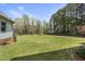 Beautiful backyard with lush green grass, a few trees, and a bright blue sky at 230 Bradley Dr, Benson, NC 27504