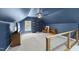 A bonus room featuring blue walls, neutral carpet, an exposed bookshelf, and an exposed beam at 230 Bradley Dr, Benson, NC 27504