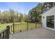 Exterior view of wood deck overlooking the yard with lush green grass and mature trees at 230 Bradley Dr, Benson, NC 27504