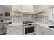 Close-up of kitchen with floating wood shelves and modern range at 230 Bradley Dr, Benson, NC 27504