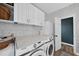 Bright laundry room featuring white cabinets, ample counter space, and modern washer/dryer at 230 Bradley Dr, Benson, NC 27504