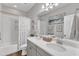 Elegant bathroom featuring double sinks with white quartz countertops and a bathtub-shower combo at 2321 Swansea Ln, Apex, NC 27502