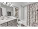 Modern bathroom with a shower-tub, white subway tile, decorative shower curtain, and gray vanity at 2321 Swansea Ln, Apex, NC 27502