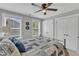 Comfortable bedroom with a dark metal bed frame, ceiling fan, and double closets providing ample storage at 2321 Swansea Ln, Apex, NC 27502