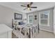 Comfortable bedroom with a dark metal bed frame, ceiling fan, and windows providing natural light at 2321 Swansea Ln, Apex, NC 27502