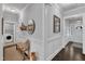 Bright hallway featuring wainscotting, a bench, and access to a laundry room and the main entrance at 2321 Swansea Ln, Apex, NC 27502