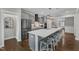 Bright kitchen features a large island with seating, stainless steel appliances, and stylish gray cabinets at 2321 Swansea Ln, Apex, NC 27502