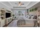 Inviting main bedroom featuring a wood accent wall, tray ceiling, and large windows for ample natural light at 2321 Swansea Ln, Apex, NC 27502