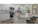 Modern kitchen featuring white cabinets, stainless steel appliances, granite countertops, and a kitchen island at 25 Granite Falls Way, Youngsville, NC 27596