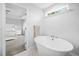 Elegant bathroom with soaking tub and view into the Primary bedroom at 254 W Odell Ln, Zebulon, NC 27597
