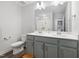 Bathroom featuring a double vanity with gray cabinets, a toilet, and a shower with a tub at 254 W Odell Ln, Zebulon, NC 27597