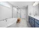 Bright bathroom featuring a soaking tub, a glass enclosed shower, and double sink vanity with marble countertops at 254 W Odell Ln, Zebulon, NC 27597