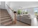 Inviting living room featuring a staircase, comfortable seating, bright windows, and stylish decor at 254 W Odell Ln, Zebulon, NC 27597