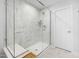 Modern glass enclosed shower with white marble tiles and shower bench at 254 W Odell Ln, Zebulon, NC 27597